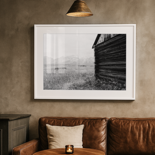 Cozy corner with brown leather sofa, wooden table, and framed artwork on a beige wall.