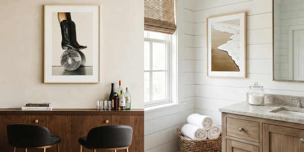 Bathroom interior with framed artwork, wooden vanity, and towels.